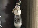 Snowman on a vase with a woodsy scene